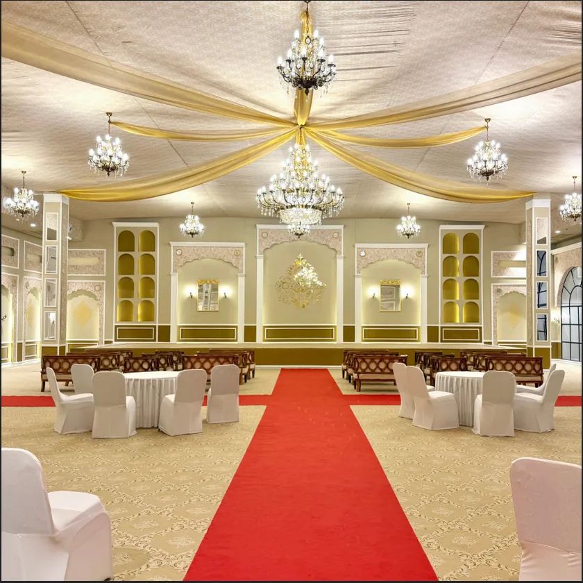 Banquet stage dressed for a wedding, with red carpet aisle